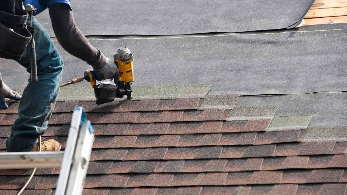 Rhino Roofing crew member inspecting shingle roofing during an on-site visit in Utah County
